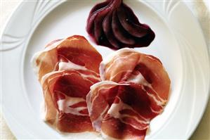 Raw ham with red wine pears