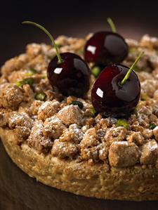 Cake decorated with pistachios and cherries