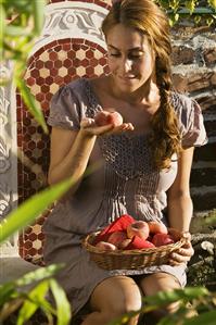 Woman with peaches on garden chair