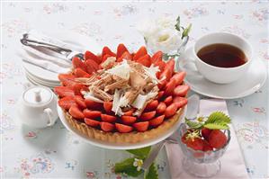 Strawberry tart with chocolate shavings, cup of coffee