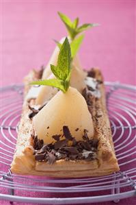 Puff pastry pear tart with grated chocolate on cake rack