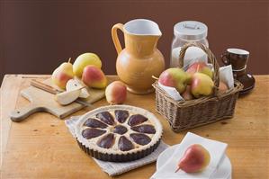 Red wine pear tart in baking tin surrounded by ingredients