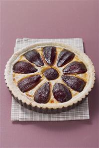 Red wine pear tart in baking tin