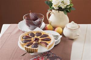 Red wine pear tart on cake stand, a piece cut