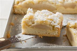 Pear crumble cake on baking tray (close-up)