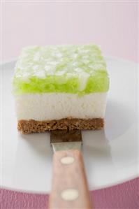 Piece of apple yoghurt cheesecake on cake knife