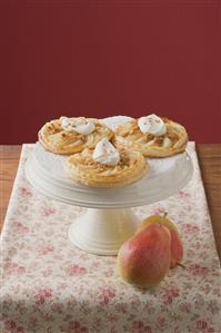 Pear tartlets with cream on cake stand