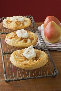 Pear tartlets with cream on cake rack