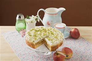 Apple cake with cream and pistachios, coffee, fresh apples