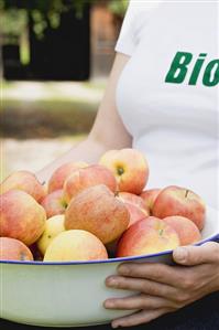 Woman holding a bowl of fresh organic apples