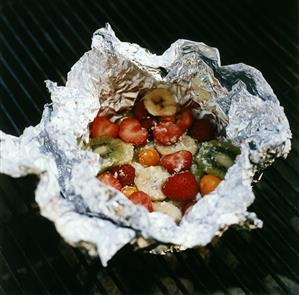 Fruit in aluminium foil on grill rack