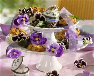 Tiered stand with biscuits, chocolates and pansies