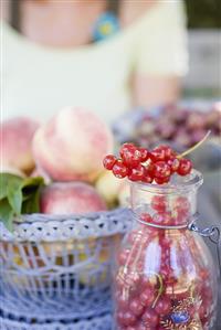 Redcurrants and peaches on a garden table