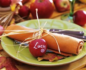 Orange napkin with raffia and apple with initial