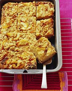 Apple cake with nut streusel, one piece on cake server