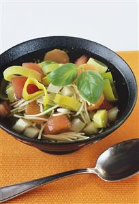 Vegetable soup with noodles and fresh basil