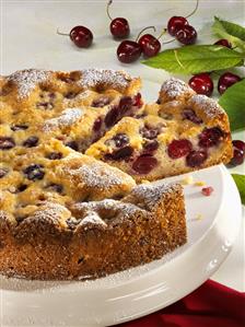 Cherry cake on cake plate, a piece cut