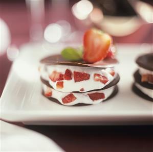 Chocolate leaves with cream and pieces of strawberry