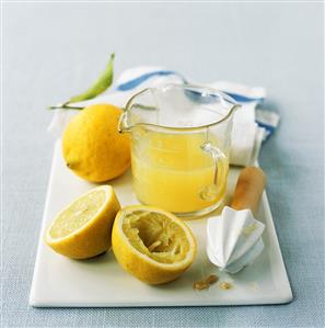 Lemons, lemon squeezer and lemon juice