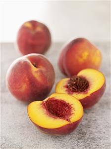 Several peaches, one halved