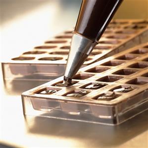 Making chocolates (piping chocolate mixture into moulds)