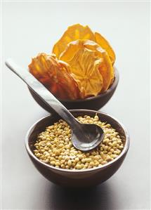 Dried sharon fruit and fennel seeds in small bowls