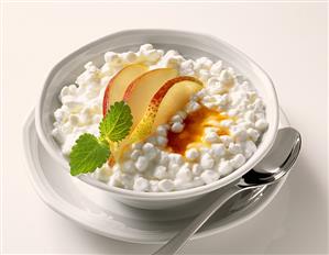 Granular fresh cheese with pear wedges in a bowl