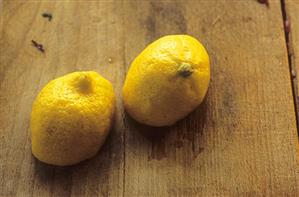 Two lemon halves on a wooden background