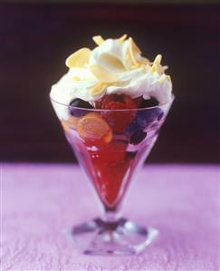 Fruit sundae with cream topping and flaked almonds