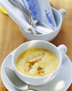 Carrot and ginger soup with apple pieces in a cup