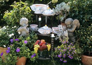 Tomato soup, bowl of fruit on tiered stand in garden