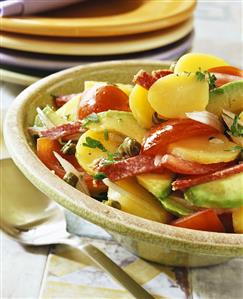 Potato salad with tomatoes, mango and salami