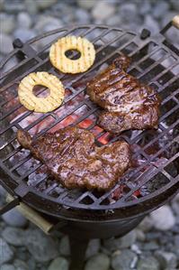 Beef steaks and pineapple slices on the barbecue