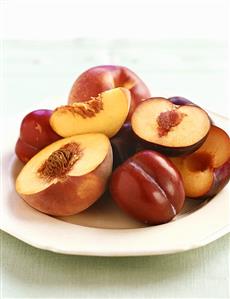 Several peaches and plums on a plate