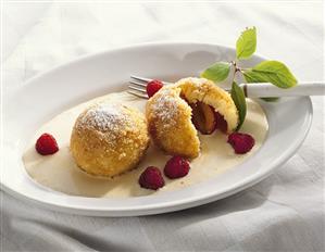 Plum dumplings with almond sauce and raspberries