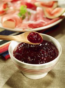 Fig jam in a small bowl with wooden spoon