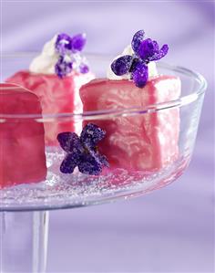 Petit fours with pink icing and violets