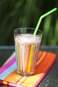 Chocolate shake in glass with straw