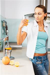 Woman holding a glass of orange juice in her hand