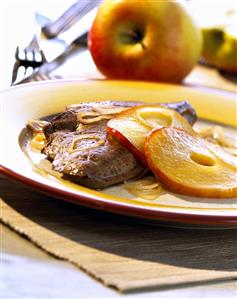 Fried liver with onion rings and apple slices