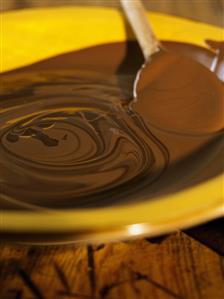 Melted chocolate with wooden spoon in a dish