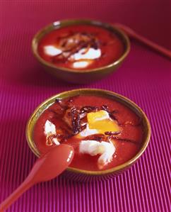 Tomato soup with poached eggs and strips of bacon