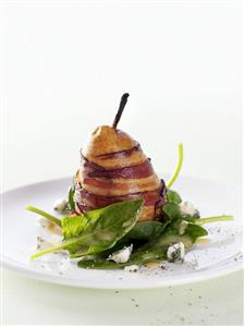 Pear wrapped in bacon on spinach salad