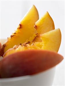 Peach slices in a small bowl