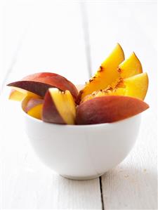 Peach slices in a small bowl