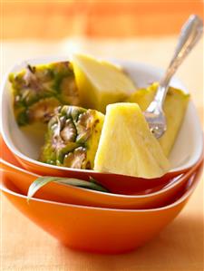 Pineapple chunks in stacked bowls with fork