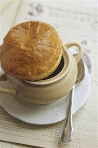 Bortsch (beetroot soup) in pot with pastry lid