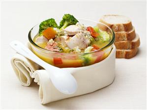 Nourishing chicken soup with vegetables, pearl barley & basil