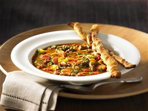 Vegetable soup with beef and bread sticks