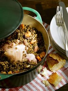 Lentil stew with knuckle of pork and carrots in pot